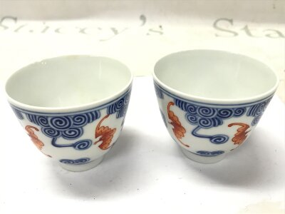 Two Chinese blue and white porcelain tea bowls decorated with iron-red bats.  six character marks at the base. 6.5cm tall