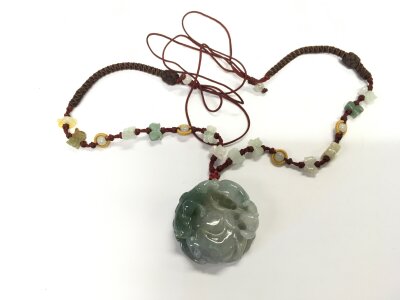 A carved jade pendant, approx diameter 4cm.