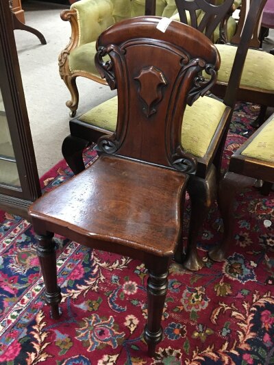 An Early Victorian mahogany hall chair with a solid shaped back and seat on turned legs.- NO RESERVE