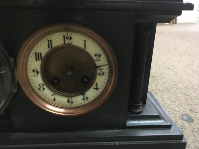 A black slate mantle clock the circle dial with Roman numerals.- NO RESERVE