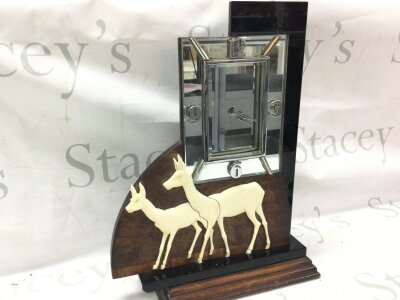 An Art Deco electric mantle clock featuring a pair of deer and mirrored clock design
