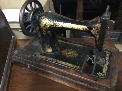 An Antique Singer Sewing machine in a dome case.