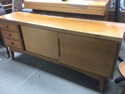 A Mid 20th century Teak sideboard the rectangle top above solid sliding doors flanked by drawers. Length 176cm