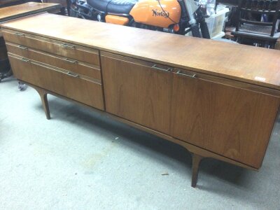 A Mid 20th century design Teak sideboard with two cupboards flanked by three graduating drawers length 199cm