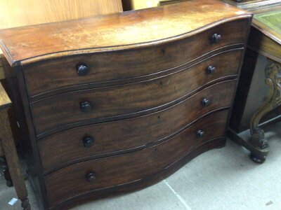 A Victorian half size serpentine chest of drawers fitted with four graduating drawers. 111cm long.depth 38cm