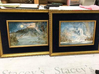 A pair of interesting gilt framed porcelain panels portraying ethereal figures at moonlit frosted lakes. Signed with a monogram WC. Picture sizes 30x20cm, Frame sizes 48x38cm
