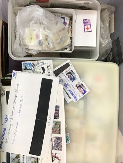 A large box containing shoe boxes full of loose stamps some postcards and other related items.- NO RESERVE