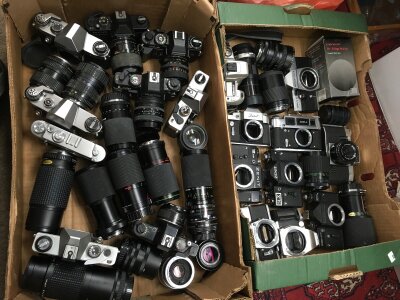 Two boxes of vintage cameras and lenses including Praktica, Zenit, Chinon