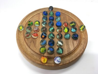 A solitaire board and marbles.- NO RESERVE