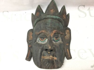 A old carved wooden oriental face possibly a mask