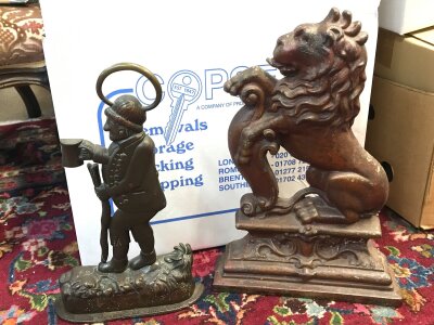 Two cast iron door stops. 35 and 40cm tall