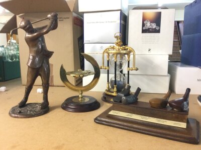 Two Modern golf ornaments including a gun metal golfer figure, an hour glass and compass