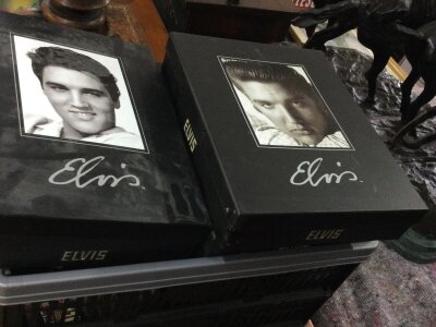 Two boxes containing Elvis DVDS and memorabilia.