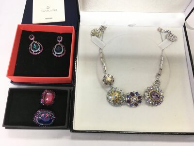 A Swarovski Regency necklace and earrings set, a pair of Orechini Donna Darling earrings and a dark double cocktail ring.