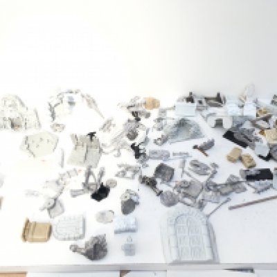 A box containing an assortment of metal and resin figures and accessories from a Warhammer collection. Mostly unpainted. Made by RAL PARTHA and others.