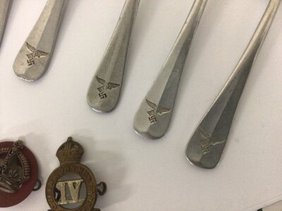A set of German Luftwaffe Canteen desert spoons and three British Military badges.