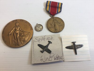 An American World War II medal. A Union National medallion and Spitfire fund badges.