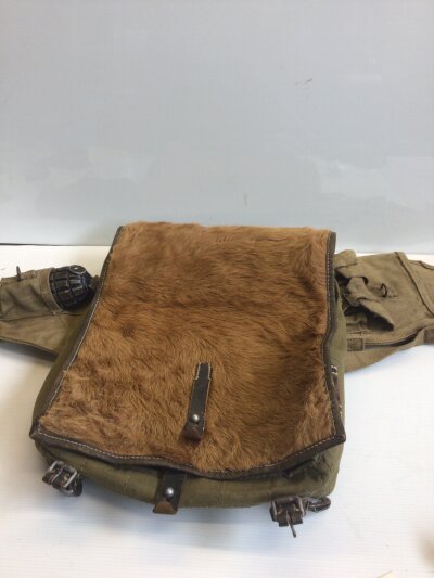 A German Third Reich Tornister Wehrmacht back pack with cow hide cover leather and canvas with makers stamp and date 1940 and other webbing with a de commissioned hand grenade.