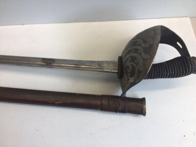 A good example of a British Victorian Cavalier Sword. With a solid engraved guard wired grip maker J R Gaunt & Son London. The blade with Royal cypher and further engraving. Leather covers scabbard.