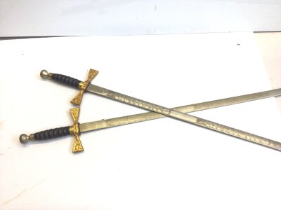 A Pair of Ornamental Wilkinson swords the etched blades with crest of Elizabeth II with gilt metal cross guards. Wired leather grips.