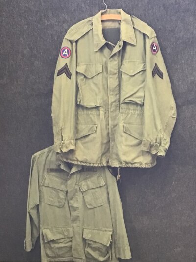 Two American Vintage Military field jackets possibly II world war or Korean War with US army Central cloth badges and rank corporal and one other with cloth name badge (2)