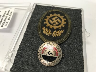 A Daf visor cap badge and a Hitler youth work badge