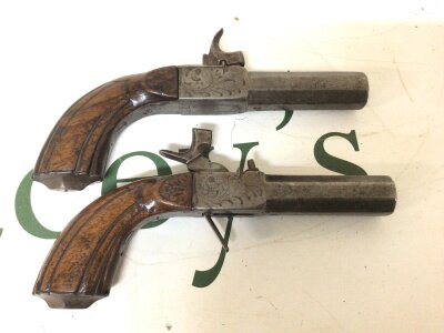 A Pair of 19th century Percussion pocket Pistols slab sided with octagonal barrels with carved walnut grips the steel action with some engraving retractable triggers length 16.5cm (2)