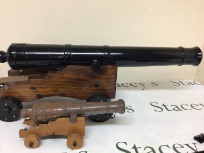 Two model canons black composition and a steel canon 70cm long 24cm high (2)