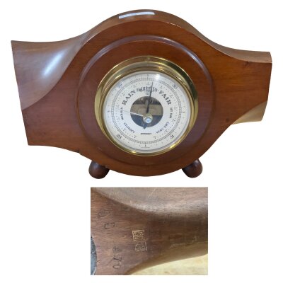 A wooden propeller Boss with various markings and fitted barometer.