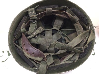 A Military helmet mid 20th century possibly Russian or Continental complete with original liner the helmet with lots of dents scratches.