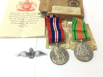 Boxed World War II medals along with a RAF pin.