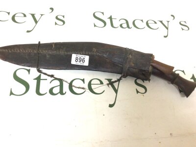 A Nepalese Kukri  Knife with a hand stitched leather scabbard and smaller side knife attached.