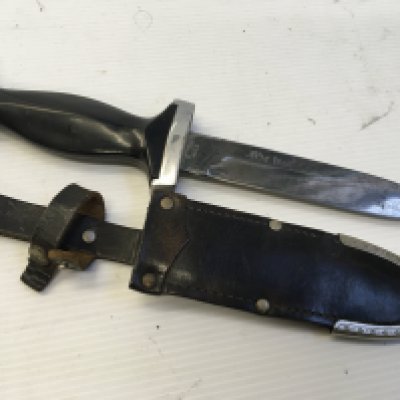 A German Knife with chrome mounts the black grip with a snake symbol the blade with an inscription leather scabbed with belt loop.