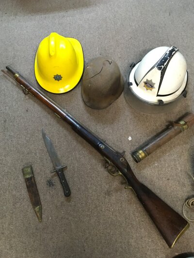 A German relic helmet, Ford Dagenham fire department helmet, British fire service association helmet, horn handled Bowie knife , vintage telescope and a replica flintlock rifle. No reserve
