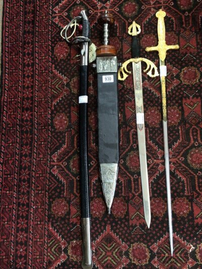 Four Replica Swords with blunt edged blades a copy of a Roman Centurion sword a light cavalry sword and two others with elaborate gilt decorated swords. (4)