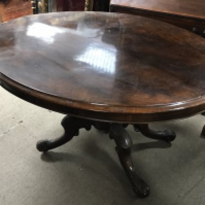 A Victorian walnut tip action table with a circular shape length 102cm x width 132cm x 75cm tall