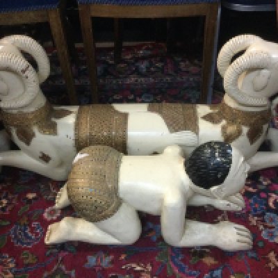 A wooden painted Indian foot rest of a two headed mythical beast, approx length 93cm plus one other in the form of a recumbent male figure, approx length 55cm. Shipping category D.
