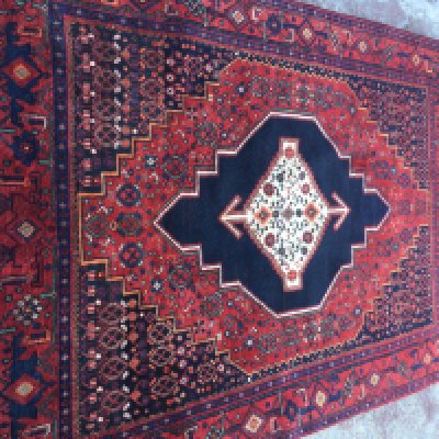 A Persian Senneh rug with geometric an floral design on a red ground .120x 160 cm