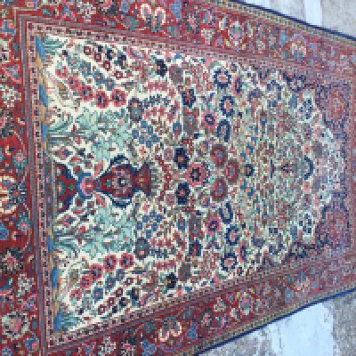 A Persian rug with floral centre and board 210 x 130 cm .