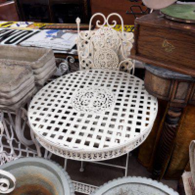 A modern white painted metalwork garden table and 2 chairs.