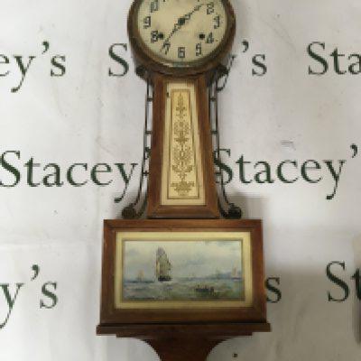An American wall clock The Newhaven clock the case with brass mounts inset with a marine view. the case surmounted with an Eagle. Length 75cm