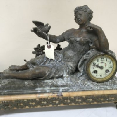 A French late 19th century clock surmounted with a figure of a reclining lady on a marble plinth length 36cm