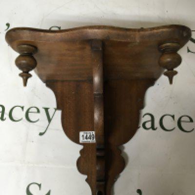 A walnut bracket possibly a clock bracket with a carved scroll support. 31cm