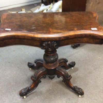 A Victorian burr walnut serpentine card table the hinged top on a turned column on carved cabriole legs.