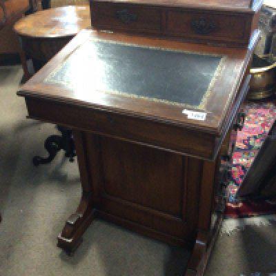 An Edwardian walnut Davenport with a hinged sloping top the sides with a flight of drawers.