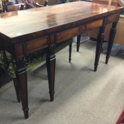 A quality George III Mahogany dining room serving table the rectangular top with an ebony banding above three drawers with four front tapering legs with stylised acanthus leave capitals 168cm long 88cm high 75cm deep.