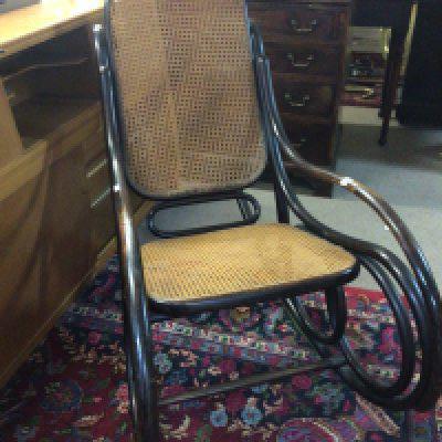 A pin early 20th century bentwood rocking chair with a burgere cane back and seat.