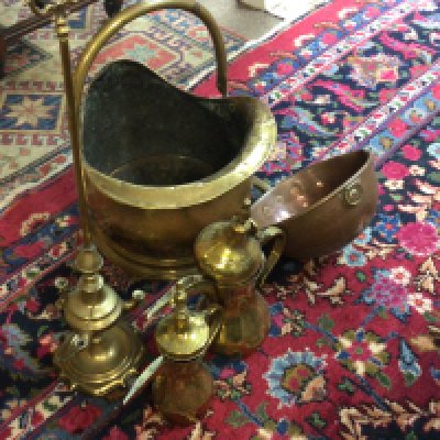 A brass coal scuttle and other copper and brass ware including a lamp.