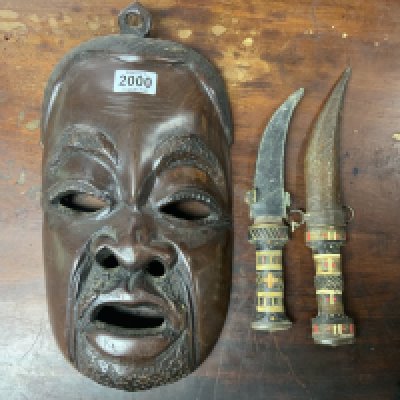 A carved hardwood tribal mask together what to bone inlaid sheathed knives.- NO RESERVE