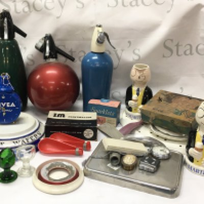 Vintage items including Cognac Martell Brandy jug figures, soda streamers , Nivea alarm clock, porcelain chocolate wafers stand , chrome Rozalex cream dispenser , brass aeroplane , glass eye baths etc . This lot cannot be posted
